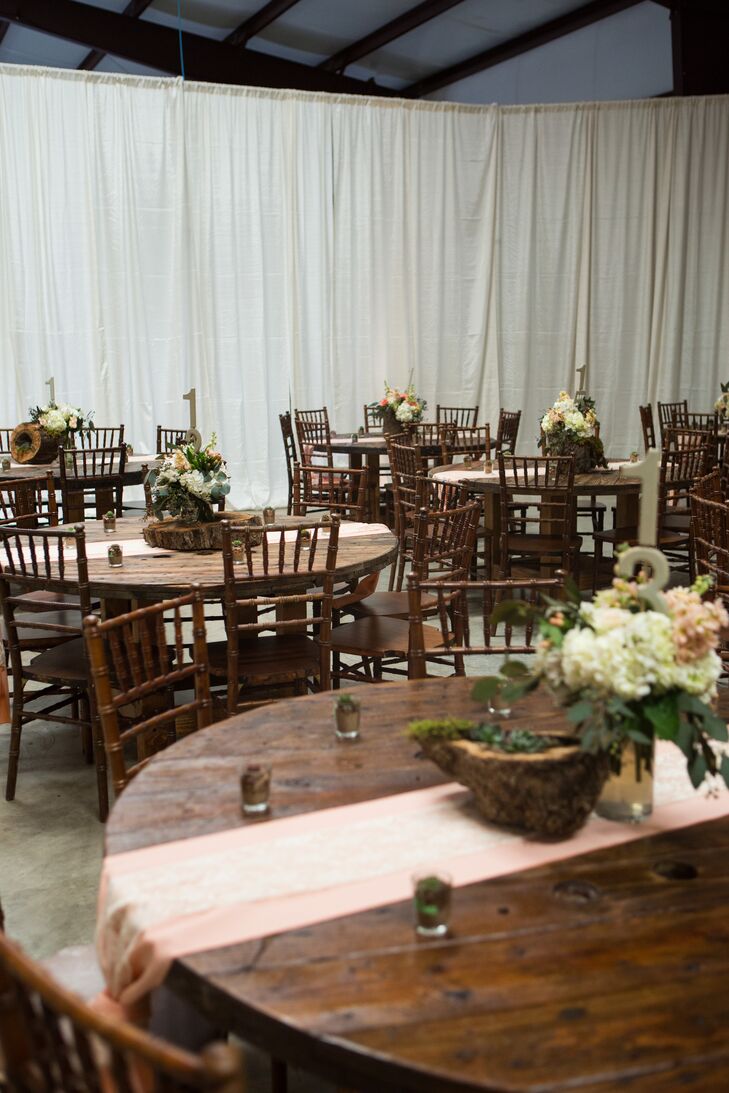 The dining tables, made from cable spools, added to the rustic atmosphere of the reception. Melinda and Bryce covered some of the tables with chalkboard paint and provided chalk for guests to write inspirational messages; after the wedding, the couple covered the tables in a clear coat and kept them!