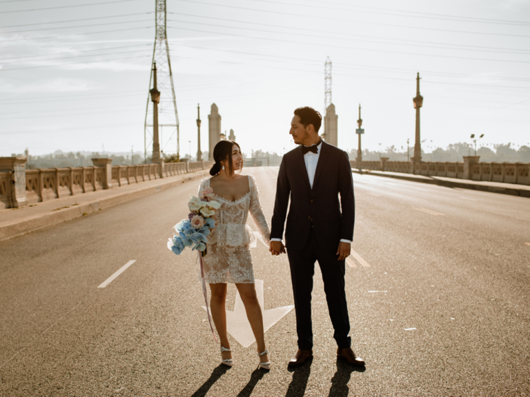 couple holding hands on bridge