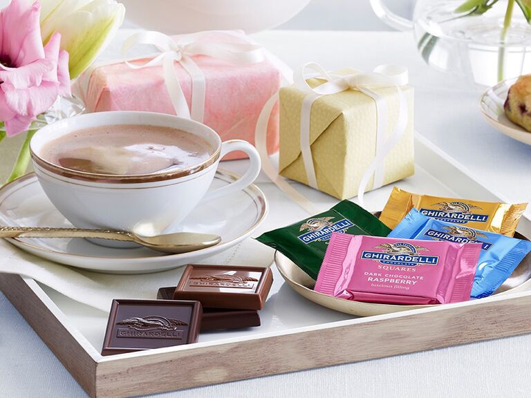 Конфеты Ghirardelli на подносе с горячим шоколадом и маленькими подарочными коробками