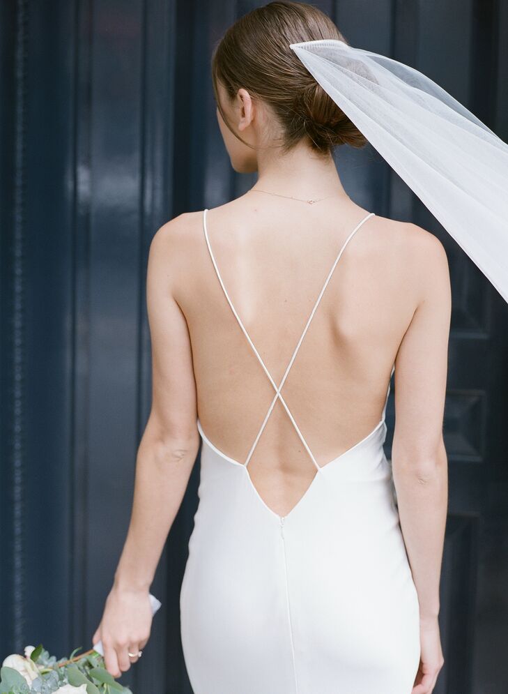 Bride Wearing Modern Form-Fitting Wedding Dress with Cross-Back Straps, Updo and Veil
