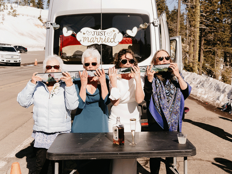 Family drinking from a shotski during the winter wedding.