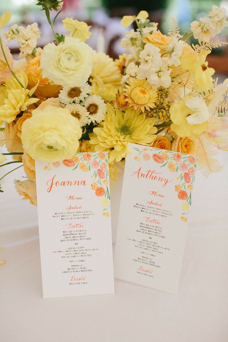 Yellow centerpiece styled with watercolor wedding programs