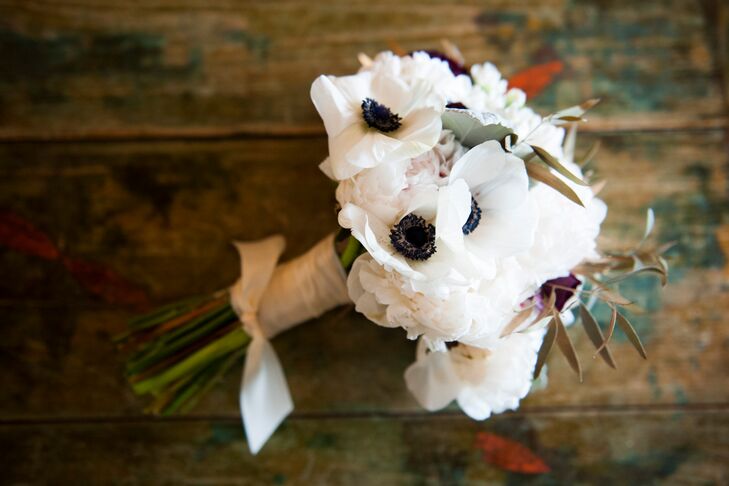Kristen carried white anemones, blush peonies and olive leaves in her lush white bouquet.