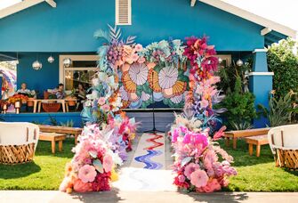 Colorful aisle runner in front of a blue house. 
