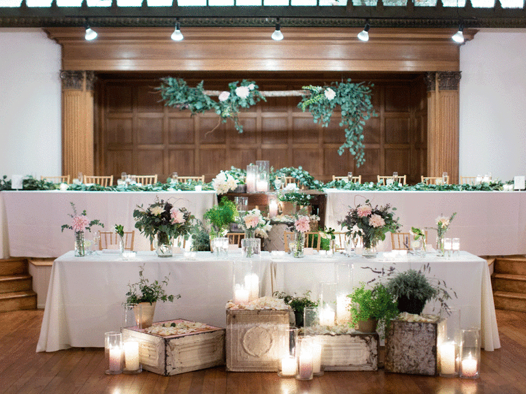 Simple yet elegant wedding head table with candles and eucalyptus.