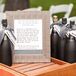 Black-painted wine bottles had black-and-white-striped ribbon wrapped around the neck. Guests signed the bottles as an alternative to a guest book.
