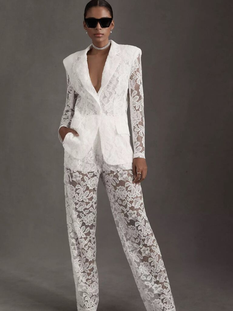 Model wears a white lace pantsuit. 