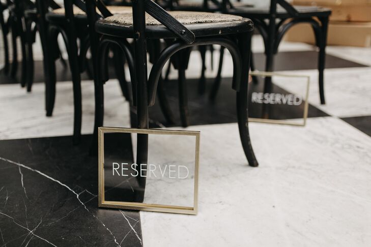 Luxurious Wedding Ceremony Decor with Black Chairs and Lucite Signage