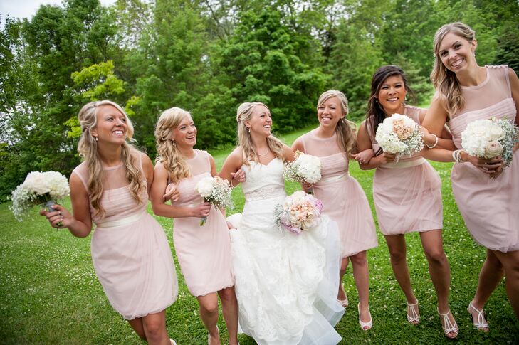 Amber's bridesmaids donned short blush bridesmaid dresses with cream-colored sashes.