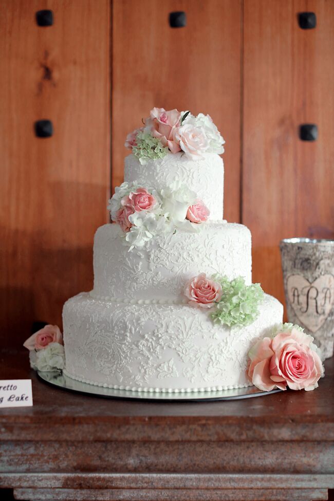 Anna and Adler's three-tier white cake had intricate floral fondant details and fresh cake flowers in white, blush and green. In addition, the cake table had five other cake flavors, so everyone could pick their favorite.