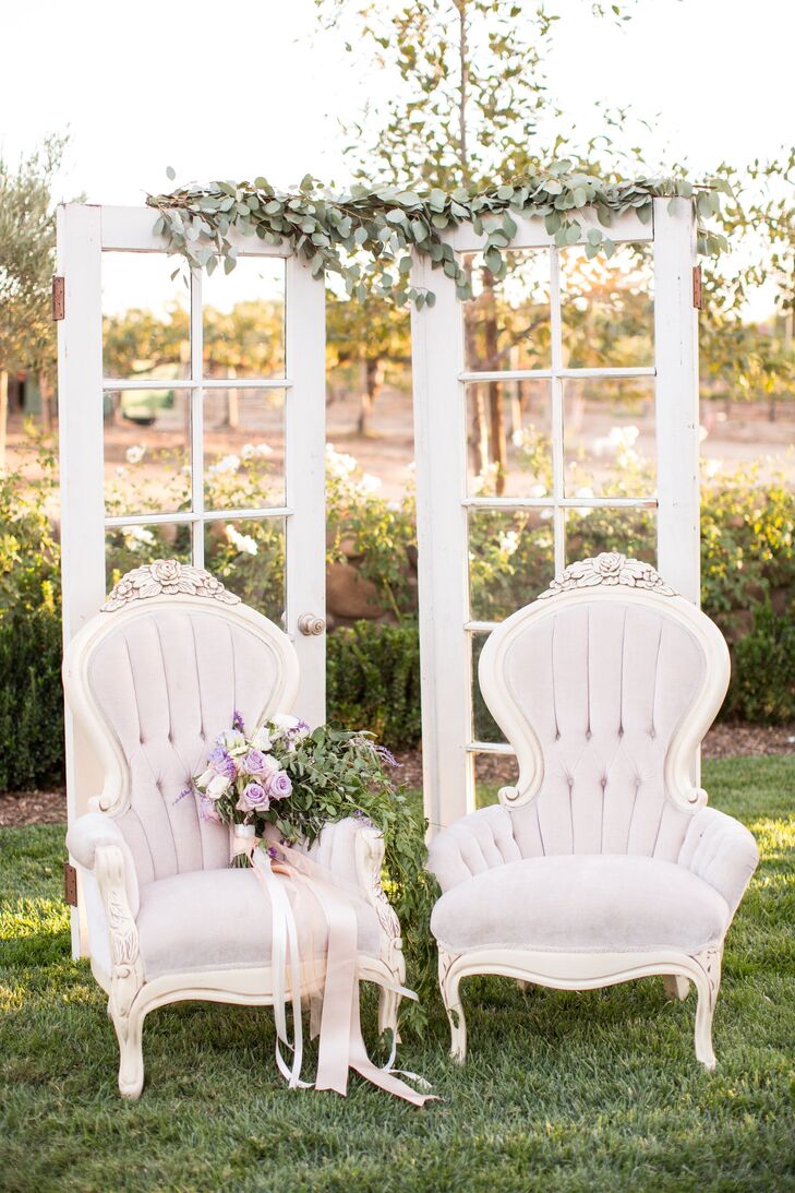 Pale lavender Louis XV chairs and an upcycled French door backdrop added an elegant, shabby-chic flair to the decor.