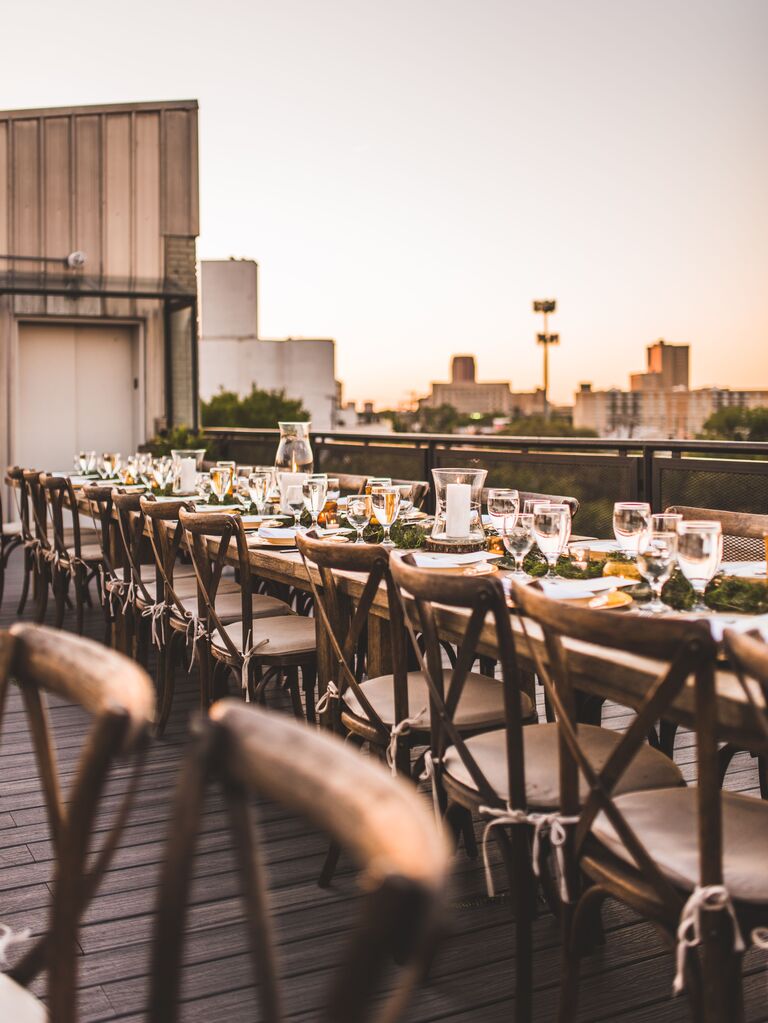 rooftop wedding reception venue with long wooden tables