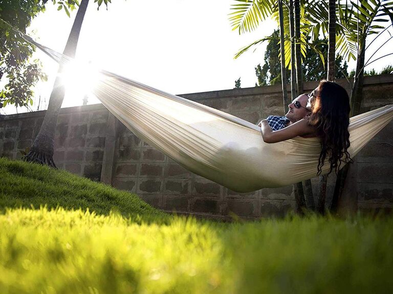 Couple relaxes in a hammock together. 