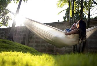 Couple relaxes in a hammock together. 