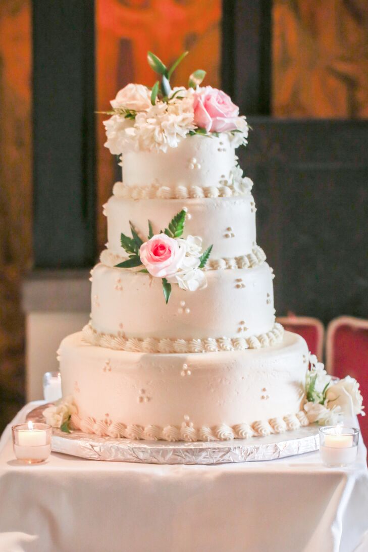 Sweet Beginnings bakery created a four-tier confection for the newlyweds, topped with fresh pastel blooms. "I wanted a classic white wedding cake with a matching exterior," Lauren says.