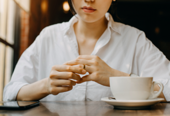 Woman thinking while holding wedding ring