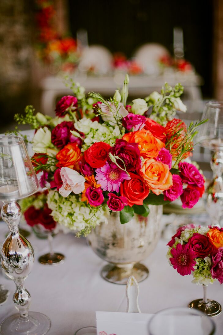 “We stuck with white and silver for the majority of the wedding because we wanted to make a statement with the flowers,” Marian says. “We wanted to embrace the colors of San Miguel de Allende with the floral color palette.” The couple brought their vision to life, decorating the tables with bountiful bouquets of roses, stock, hydrangeas and mums in brilliant shades of deep pink, red, burgundy and coral orange.