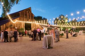 Cocktail Tables Outside Ranch Barn Venue at Night Under String Lights