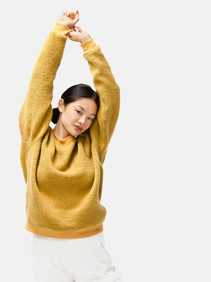 Model wearing a bold and bright crewneck made out of megafleece fabric 