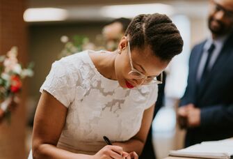 Bride signs a marriage license.