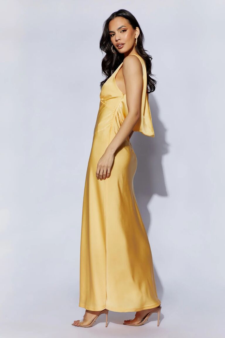 Model wears a silk gown with a cowl back. 