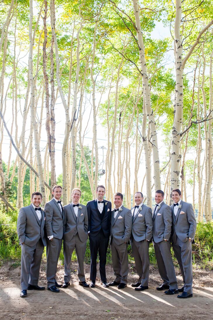 Brett wore a two-tone black tuxedo and his groomsmen wore gray tuxedos for a softer look. They all wore black bow ties and blush pocket squares.