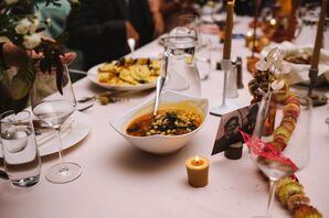 Dining Table With White Linen, Comforting Soup and Other Dinner Foods, Candles