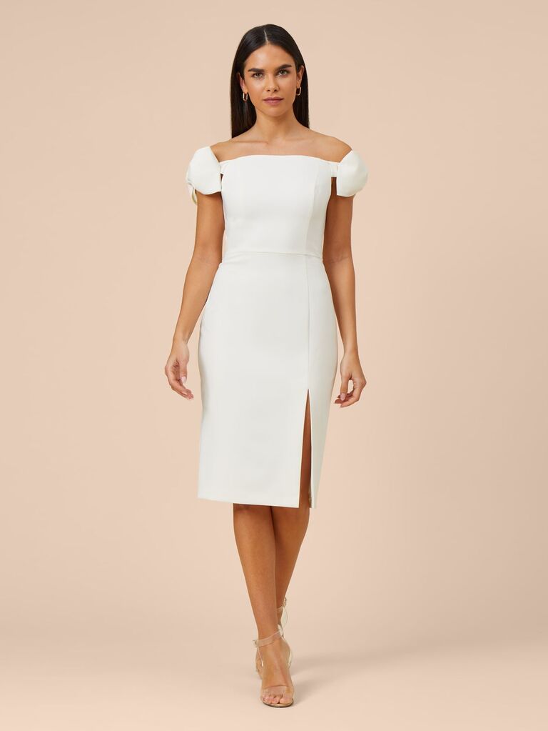 Model wears a classy off-the-shoulder white dress. 
