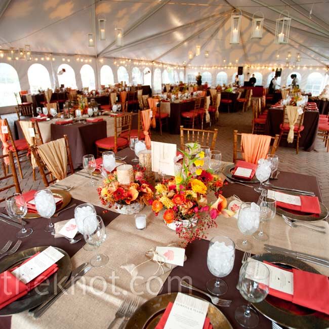 Dinner was served inside a heated tent decorated with orange uplighting. Guests sat at tables topped with brown and tan linens.