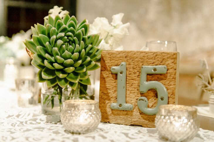 Large wooden blocks had cast iron numbers depicted on the front, marking tables for friends and family to find their seats. In addition to the number, each dining table had votive candles and a succulent decorating its surface.