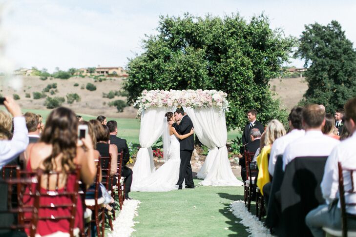 As 120 guests looked on, Bree and Greg shared their first kiss under a fabric-draped wedding arch topped with a rose garland on the grounds of Santaluz Club in San Diego, California. "I have always wanted a soft and romantic garden wedding," Bree says.