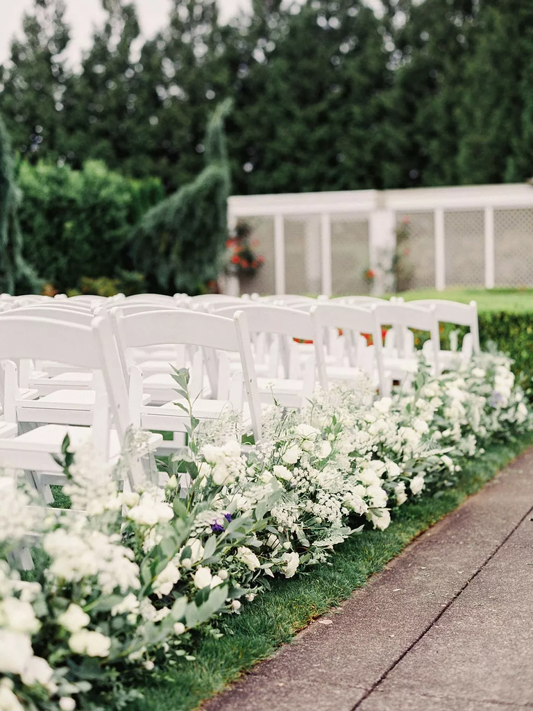 White flowers guide guests up the wedding aisle.