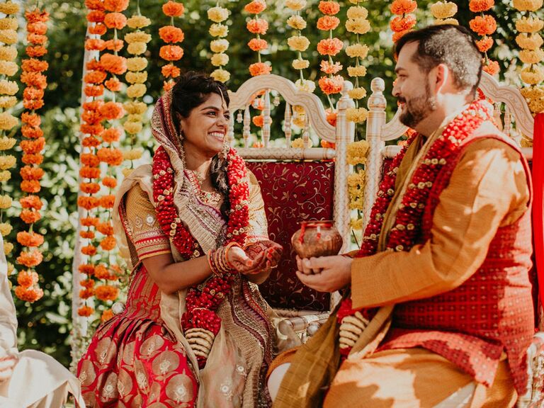 Indian bride and groom during wedding ceremony with yellow and orange fall wedding color scheme
