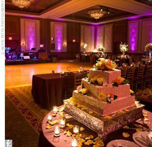 Topped with fresh roses, white dendrobium orchids, and surrounded by flower petals, Harini and Andrew's cake really added to the reception decor with its intricate mehndi-inspired scrollwork.