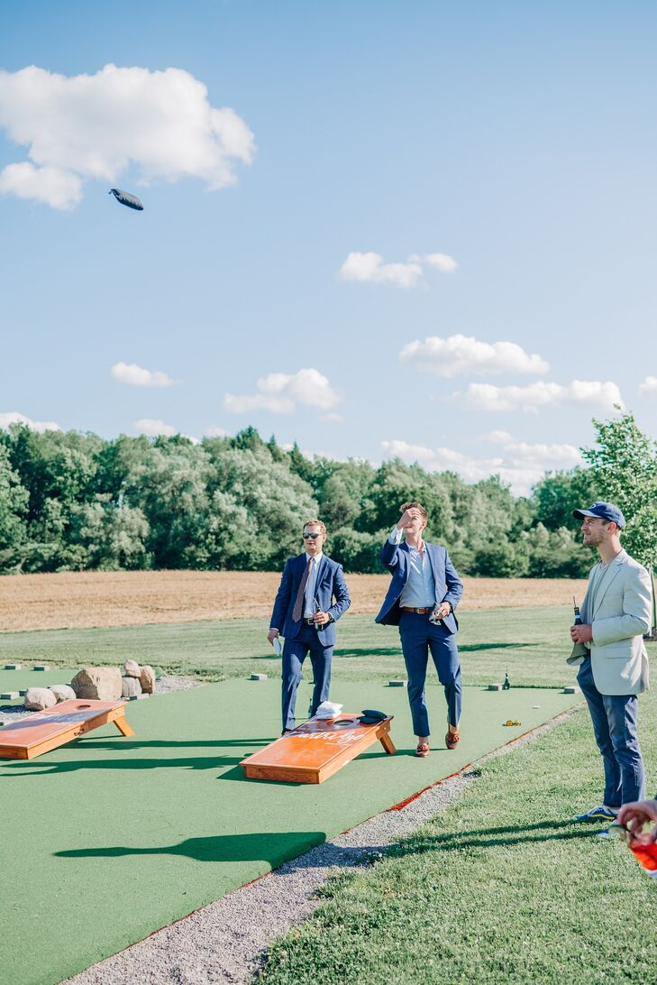 Guests Play Cornhole Game at Summer Garden Wedding