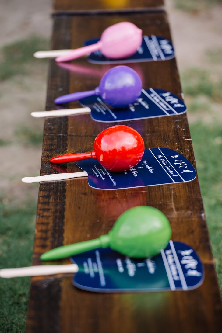 Before they even got to the reception, guests were encouraged to have some fun. Every seat had a navy (to keep away the heat) and a bright-colored maraca to shake during the couple's first kiss.