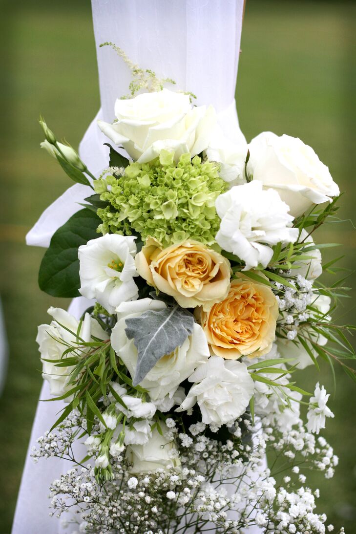 The couple accented their wedding with arrangements of white roses, green hydrangea, white lisianthus and pale yellow garden roses.