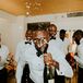 Groomsmen and Groom Getting Ready in Tuxes, Spraying Champagne in Groom's Face