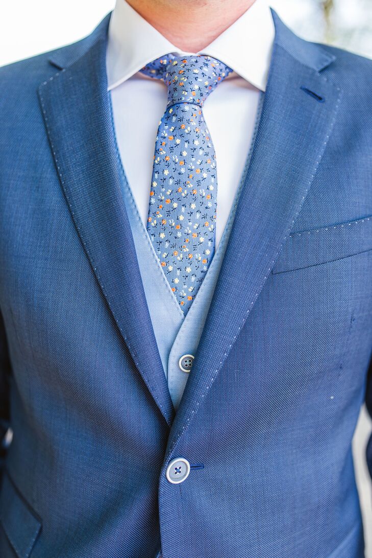 Jan wore a modern blue suit with a light blue vest and a floral blue tie.