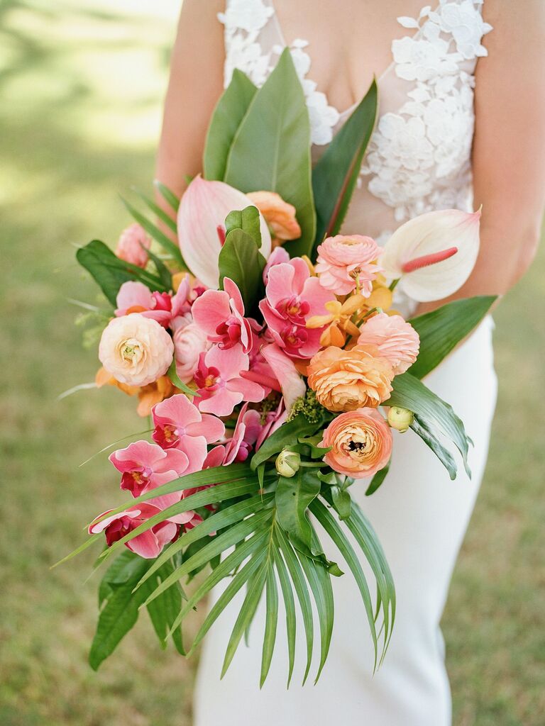 tropical cascade wedding bouquet with palm leaves, pink phalaenopsis orchids, anthurium, and ranunculus