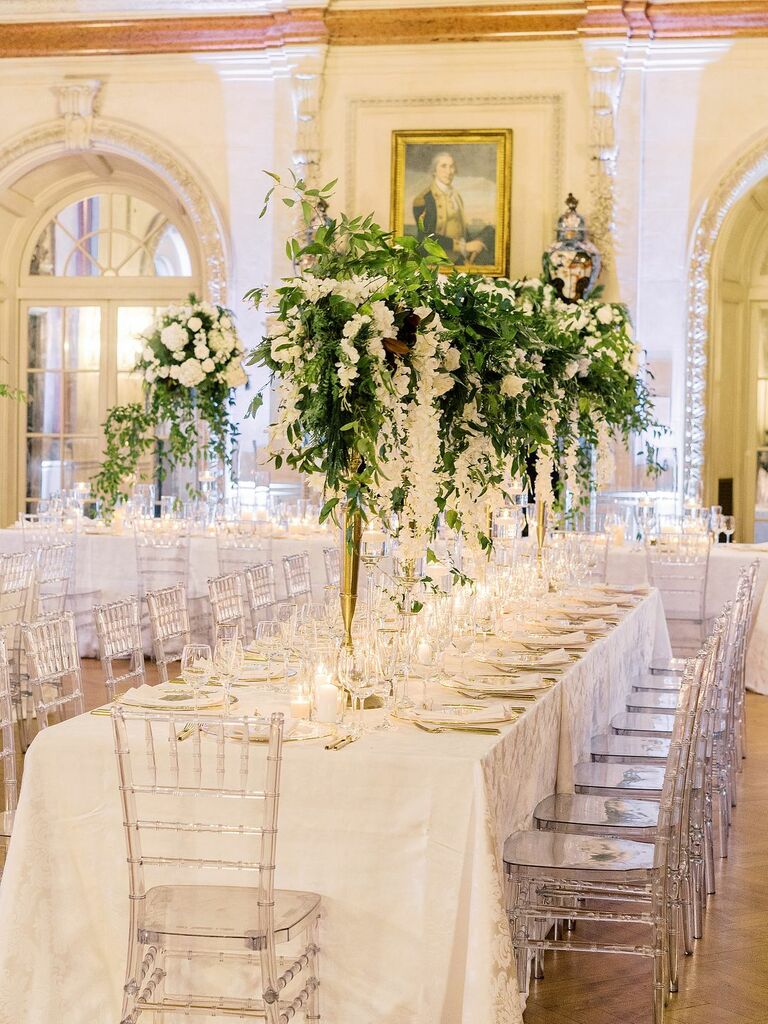 Romantic white reception decor with tall greenery centerpieces