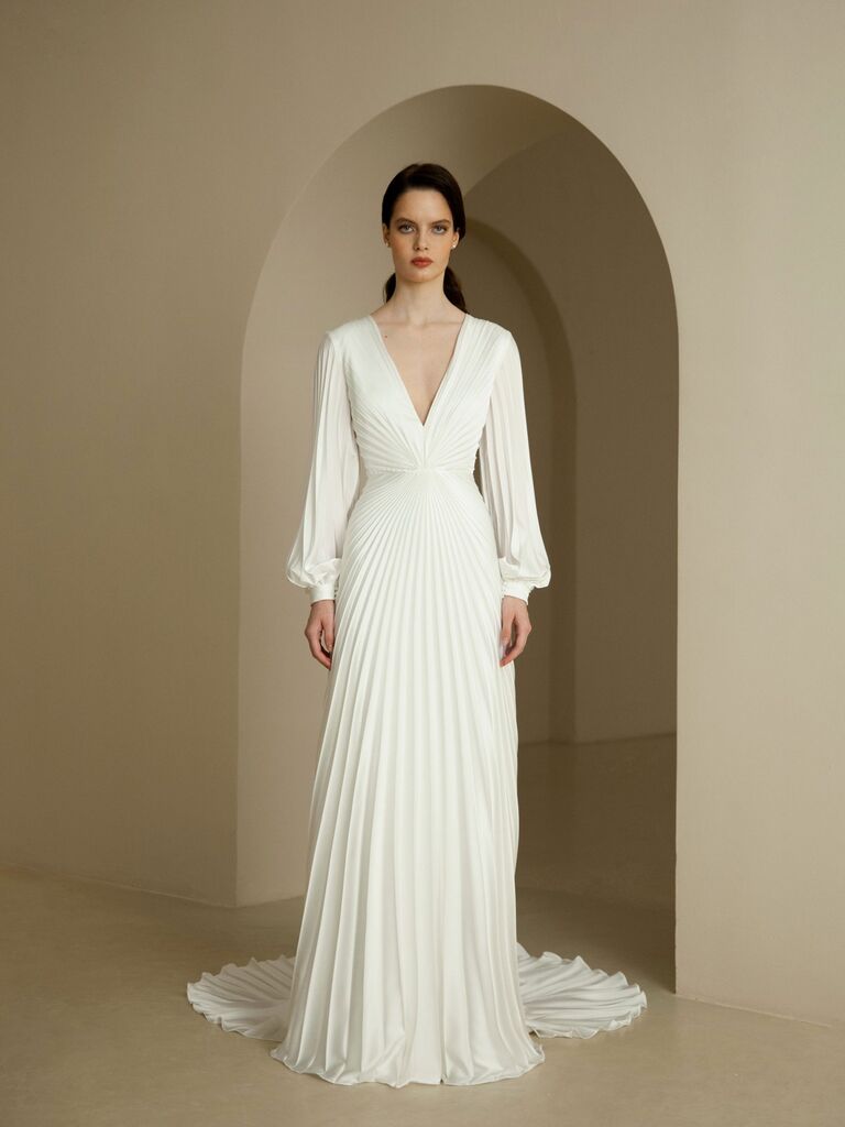 Model wears a long sleeve dress with chic pleating. 