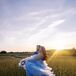 Sunset Photo of Bride in Blue Dress Dancing in Field