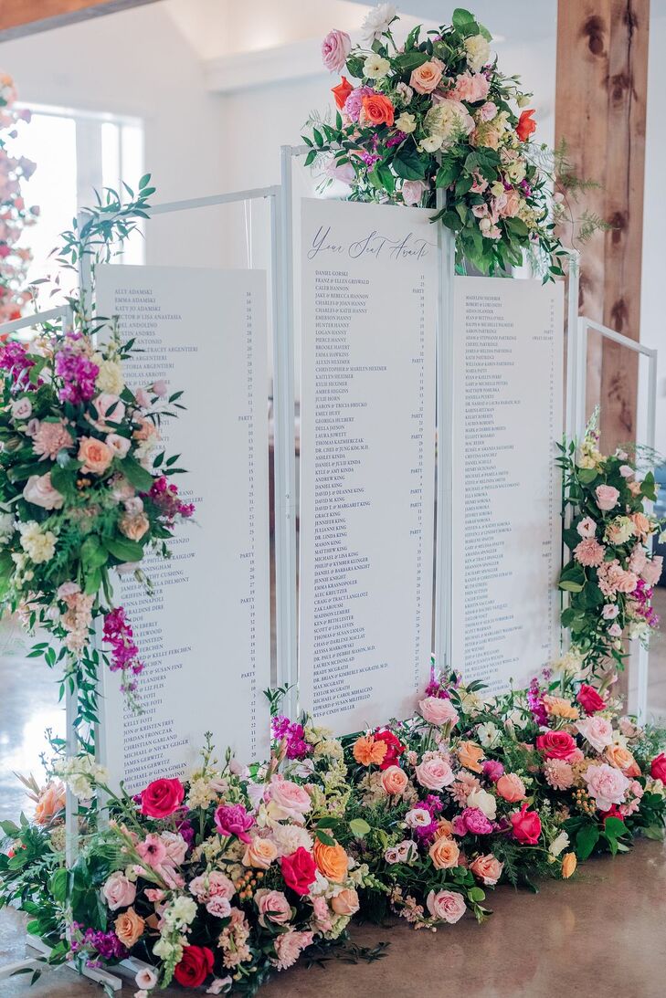 Sophisticated Seating Chart Accented With Bright Flower Arrangements at a Summer Reception