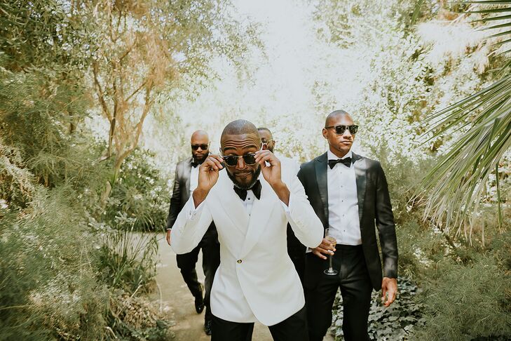 Groom in White Tuxedo Jacket Leading Groomsmen Through Trees, Garden With Sunglasses, Playful