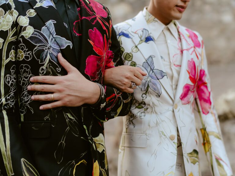 two grooms wearing patterned suit jackets with viva magenta floral print