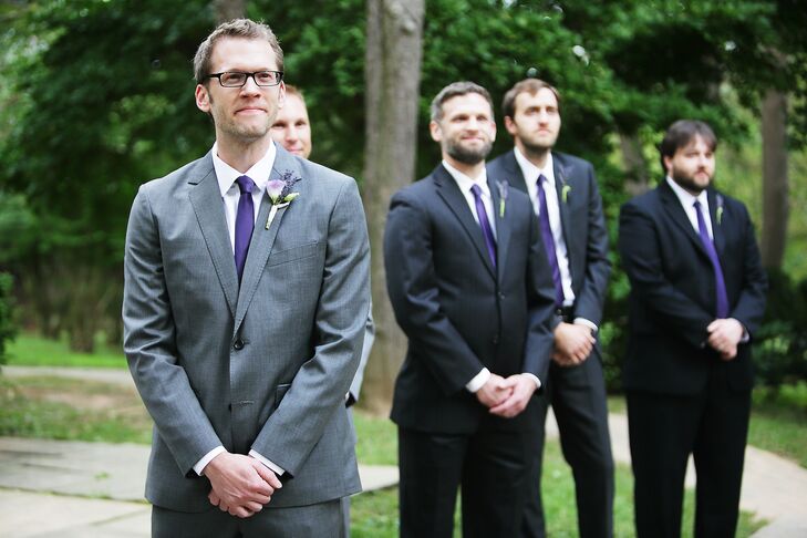 Todd wore a gray Bonobos suit on his wedding day. He also wore a purple tie and lavender boutonniere. His groomsmen wore black suits with purple ties.