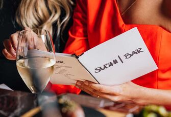 Woman holding menu at Sushi Bar ATX