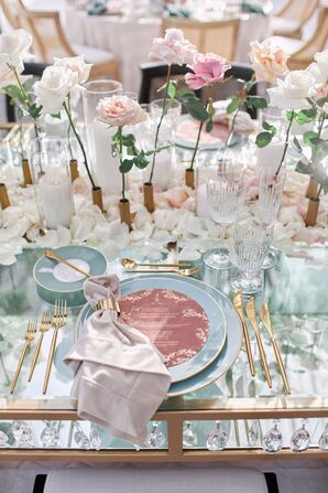 Place Setting on Glass Table With Teal Plates and Gold Flatware