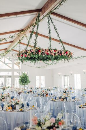 Hanging Floral Installation of Pink Flowers Over Round Tables With Blue Linens